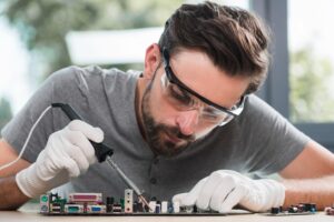 portrait-young-man-soldering-computer-circuit-workshop